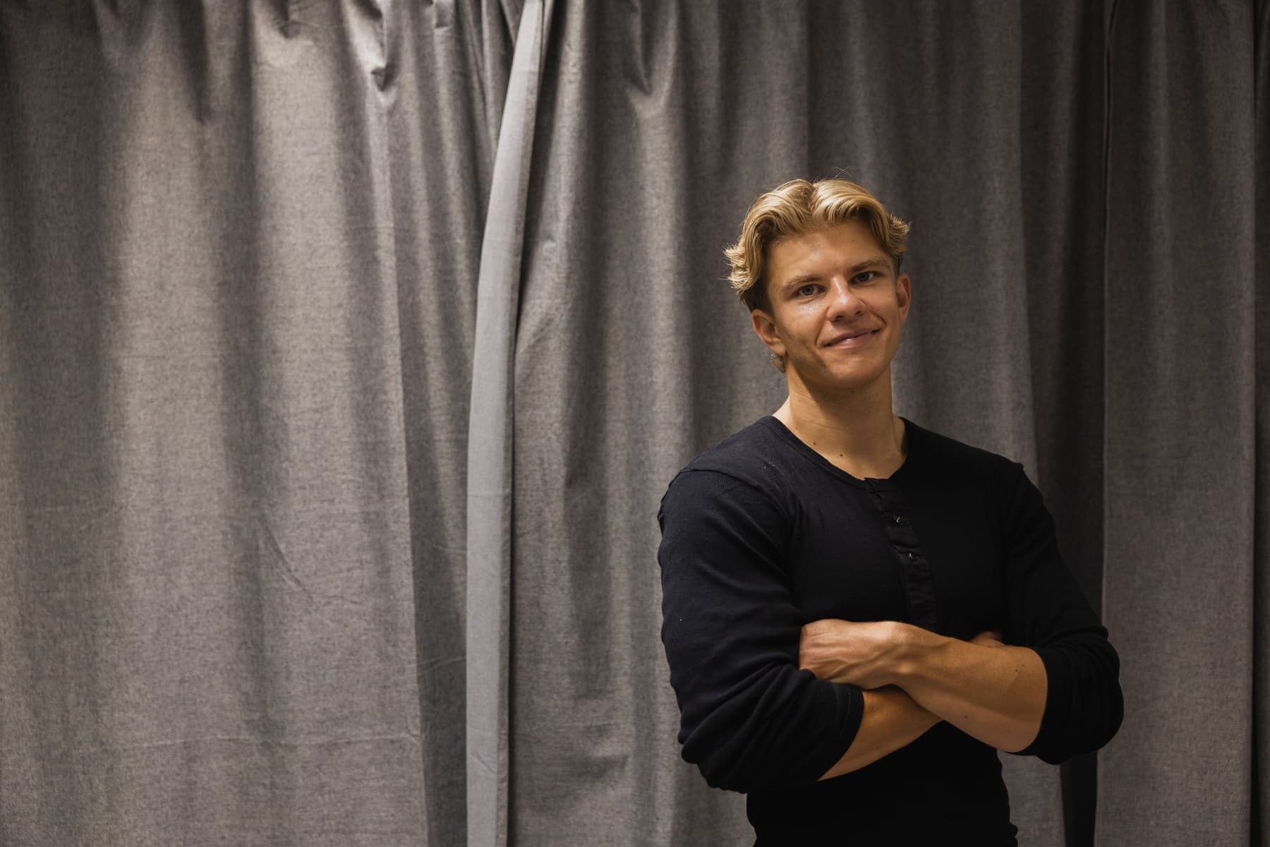 Elias Boisen Bonde med korslagte arme foran et gråt sceneforhæng